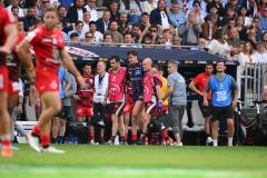 Damian Penaud soutenu par deux soigneurs pour sortir du terrain. (A. Mounic/L'Équipe)